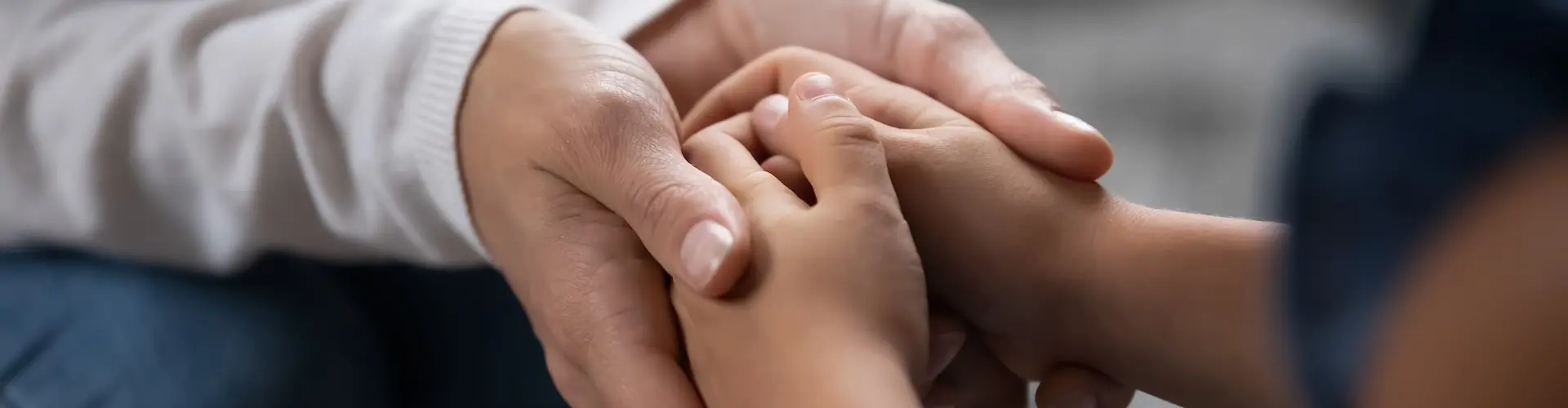 Two pairs of hands clasping together