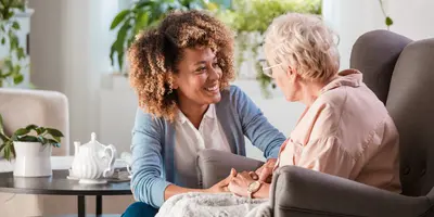 Support worker talking to someone and drinking tea