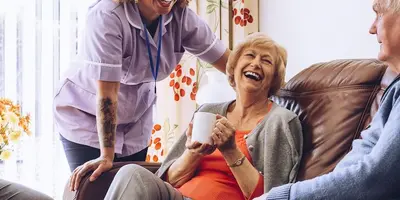 Care assistant in conversation with three older people
